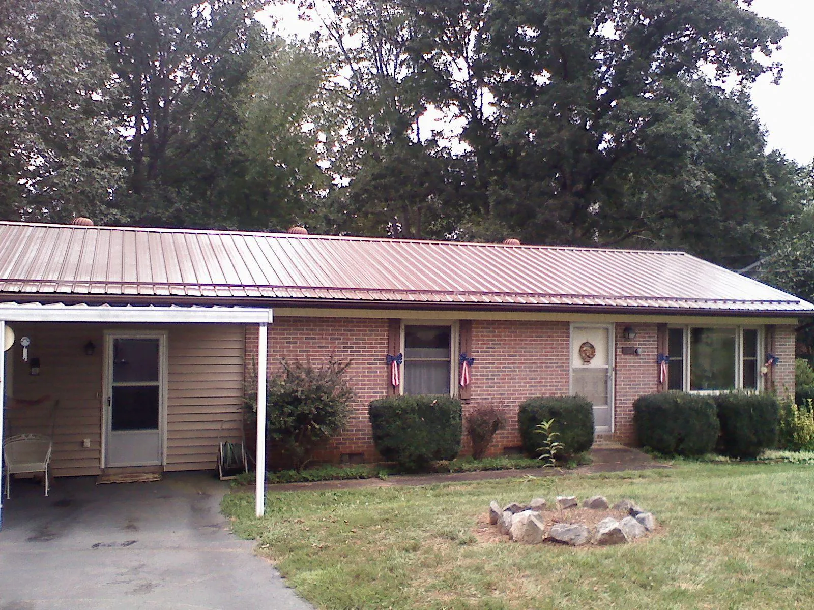 Bronze metal roof and carport on a brick ranch home — Roof Repair work by our crew in Turkey